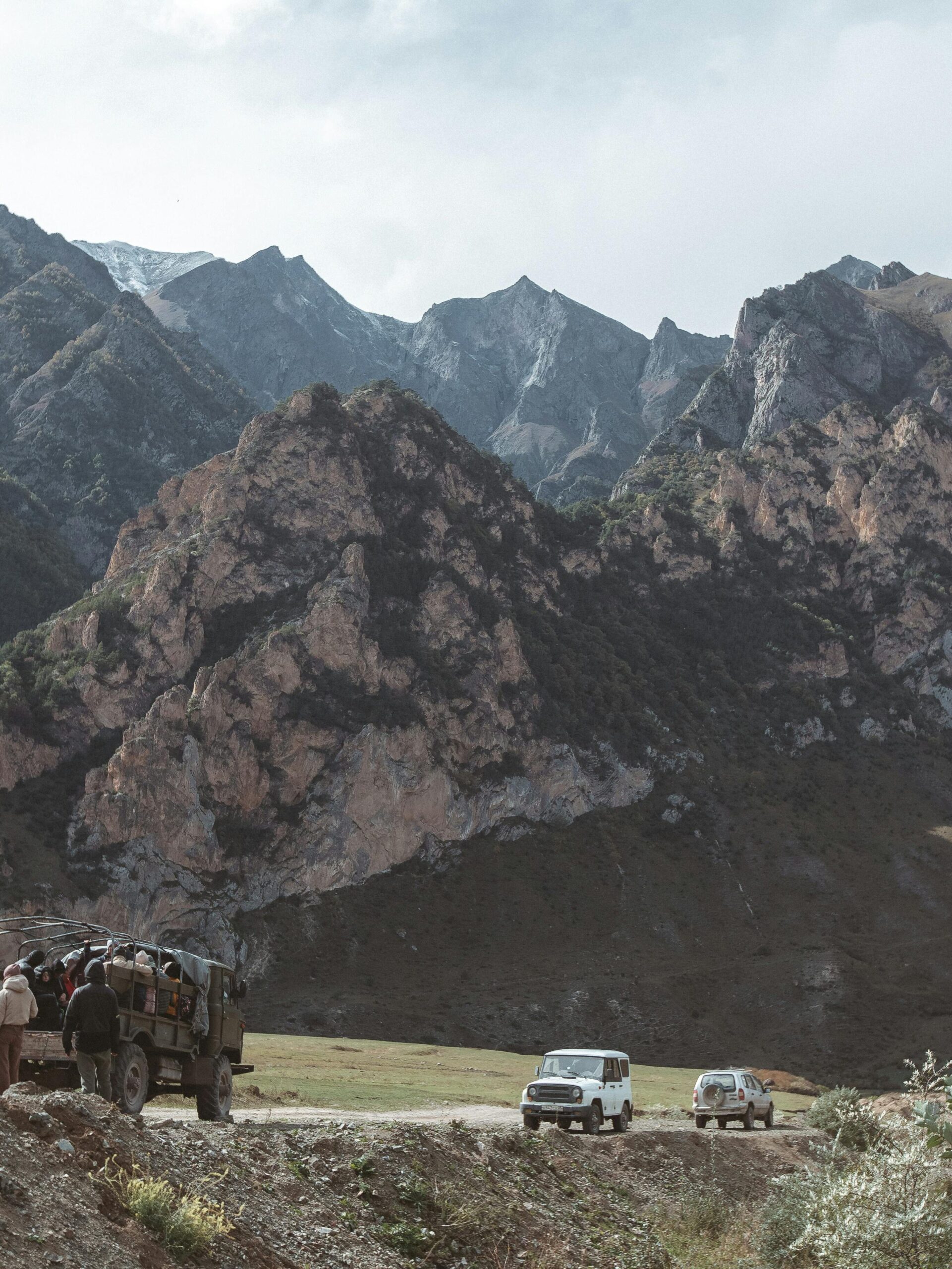 Group traveling by 4x4 SUVs through dramatic mountain landscape, perfect for adventure travel stock photo.